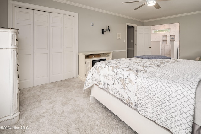 carpeted bedroom featuring ornamental molding, a closet, and ceiling fan