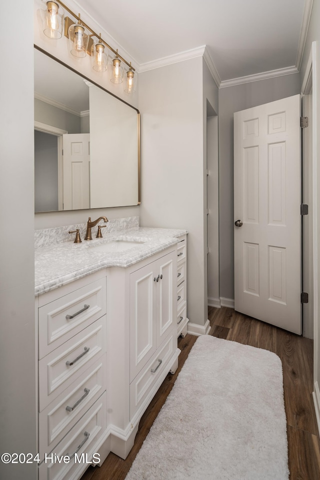 bathroom featuring vanity, hardwood / wood-style floors, and crown molding