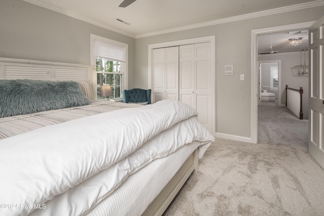 carpeted bedroom featuring crown molding, a closet, and ceiling fan