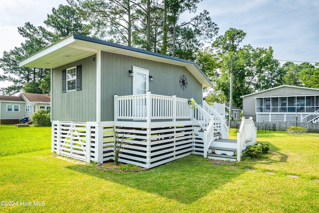 back of property with a yard and a deck