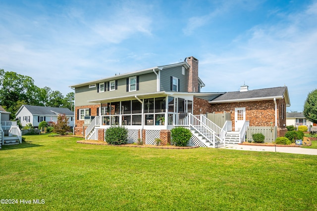 view of front of home with a front yard and a sunroom