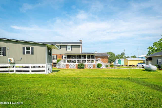 rear view of property featuring a lawn and a sunroom