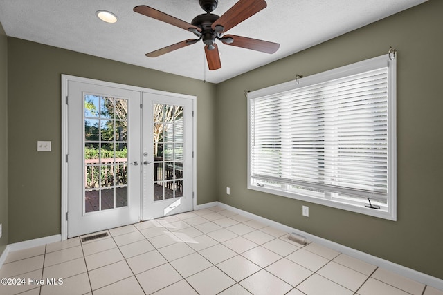 tiled spare room with french doors, a textured ceiling, plenty of natural light, and ceiling fan