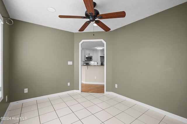 empty room featuring ceiling fan and light tile patterned flooring