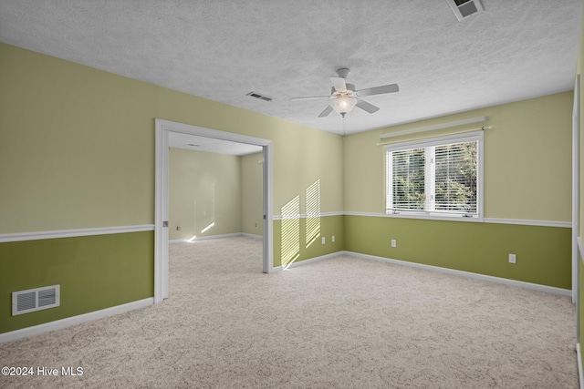 carpeted spare room with a textured ceiling and ceiling fan