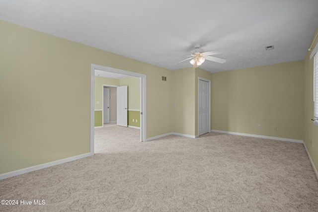 carpeted spare room with ceiling fan