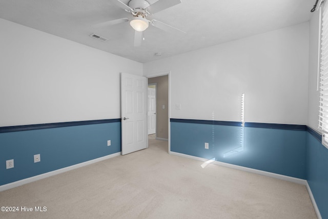 spare room with light carpet and ceiling fan