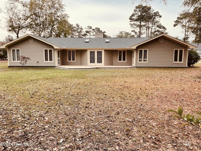 rear view of property with a yard and a patio