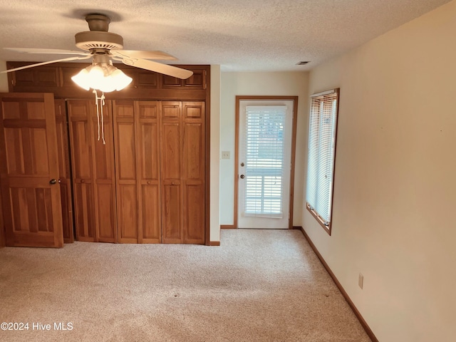 interior space with ceiling fan and a textured ceiling