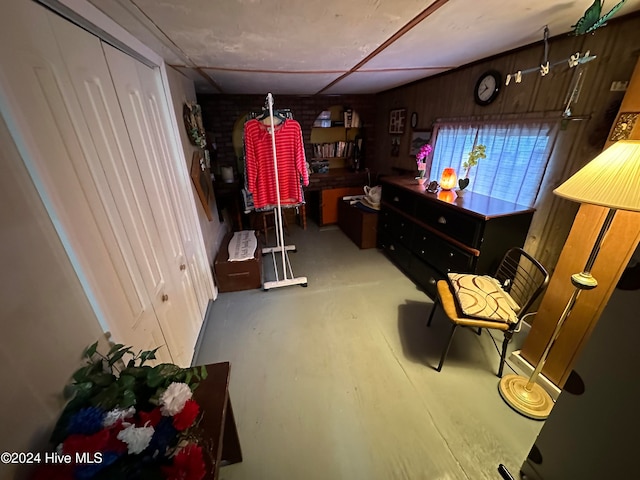 interior space with concrete flooring and wooden walls