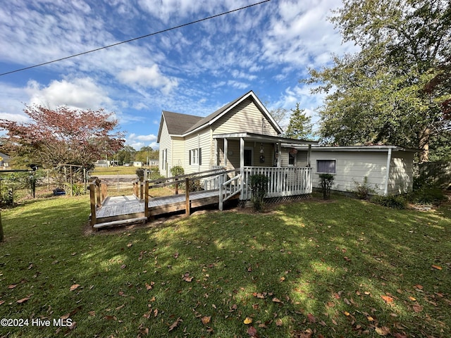 rear view of house featuring a yard and a deck