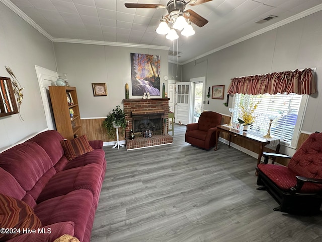 living room featuring ceiling fan, ornamental molding, a brick fireplace, and hardwood / wood-style floors