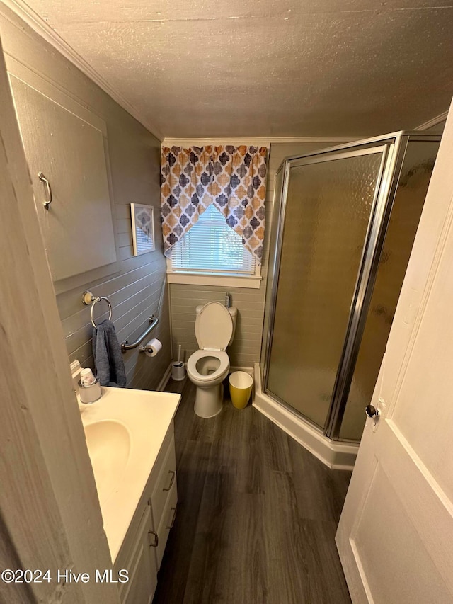 bathroom with a shower with door, a textured ceiling, toilet, vanity, and hardwood / wood-style flooring