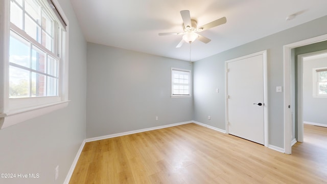 unfurnished bedroom with multiple windows, ceiling fan, and light hardwood / wood-style floors