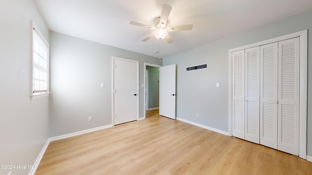 unfurnished bedroom featuring ceiling fan, a closet, and light wood-type flooring