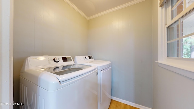 washroom with washing machine and dryer, light hardwood / wood-style floors, and ornamental molding