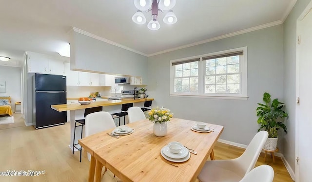 dining area featuring light hardwood / wood-style flooring and ornamental molding