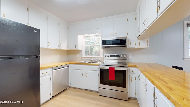 kitchen with white cabinets, stainless steel appliances, light hardwood / wood-style flooring, and sink