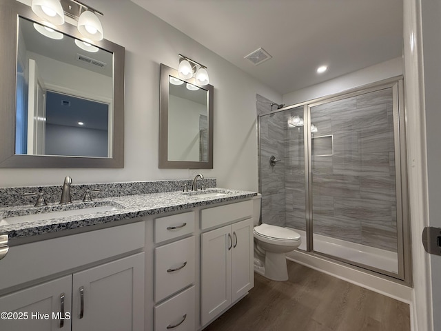 bathroom featuring hardwood / wood-style floors, an enclosed shower, vanity, and toilet