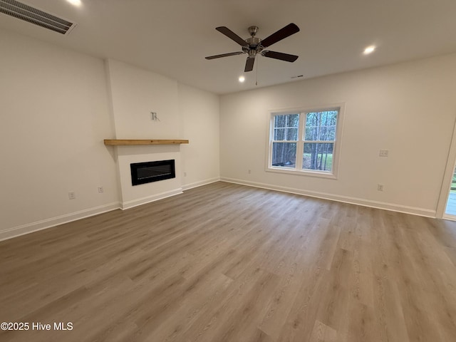 unfurnished living room with hardwood / wood-style flooring and ceiling fan