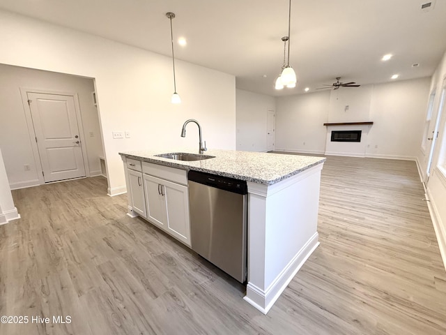 kitchen featuring white cabinetry, dishwasher, light stone countertops, sink, and decorative light fixtures