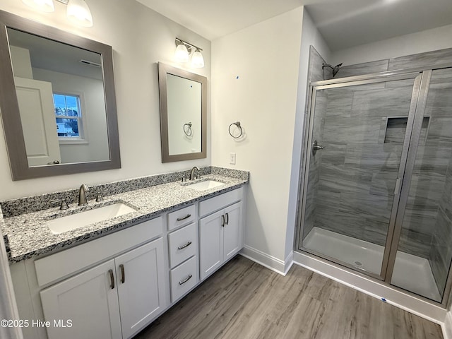 bathroom with vanity, wood-type flooring, and an enclosed shower