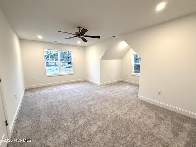 bonus room with ceiling fan, a healthy amount of sunlight, light carpet, and vaulted ceiling