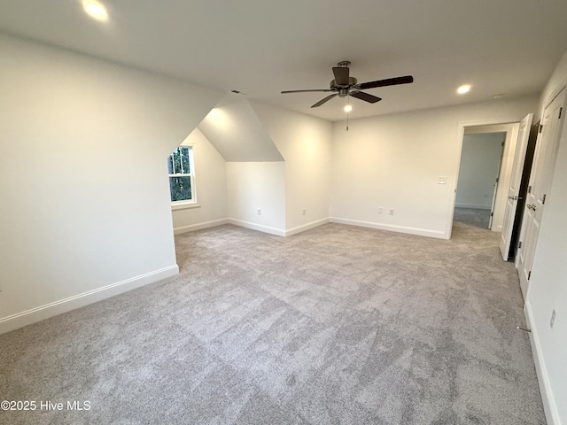 additional living space featuring ceiling fan, lofted ceiling, and light carpet