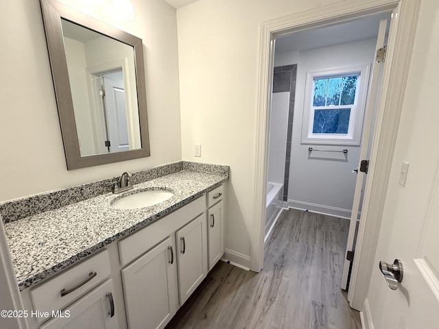 bathroom featuring shower / bathing tub combination, hardwood / wood-style floors, and vanity