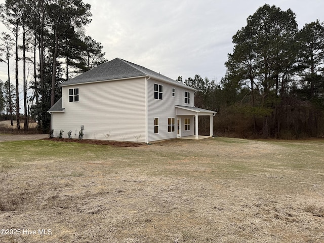 view of side of home with a yard