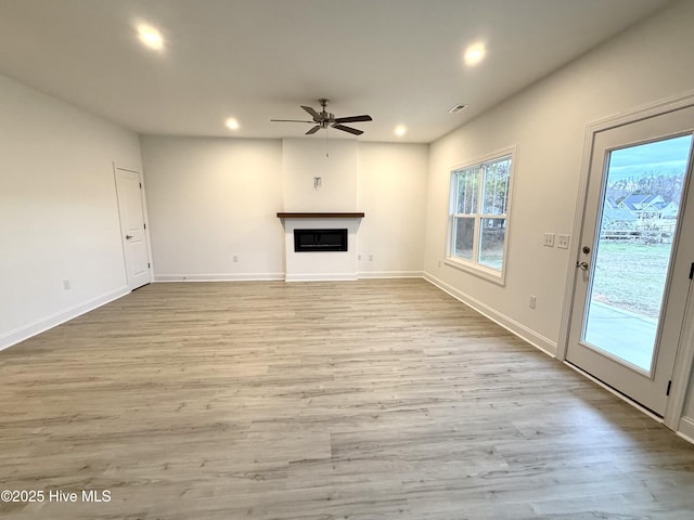 unfurnished living room featuring ceiling fan and light hardwood / wood-style floors