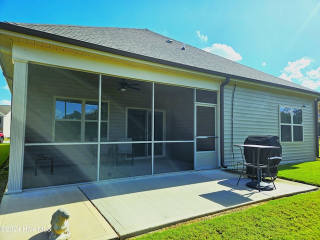 rear view of property with a patio, ceiling fan, a sunroom, and a lawn