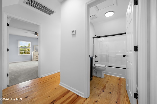 bathroom featuring lofted ceiling, bath / shower combo with glass door, hardwood / wood-style flooring, ceiling fan, and toilet