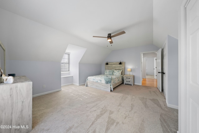 unfurnished bedroom with light colored carpet, vaulted ceiling, and ceiling fan