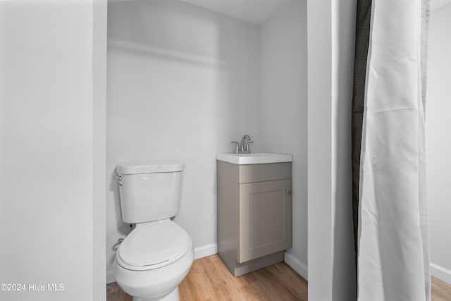 bathroom with hardwood / wood-style flooring, vanity, and toilet