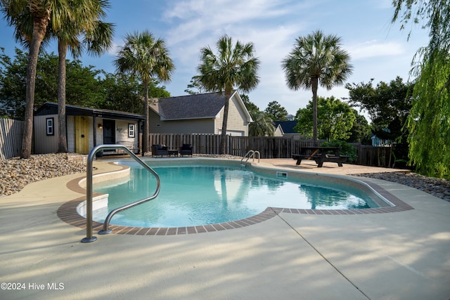 view of swimming pool with a patio area and an outbuilding