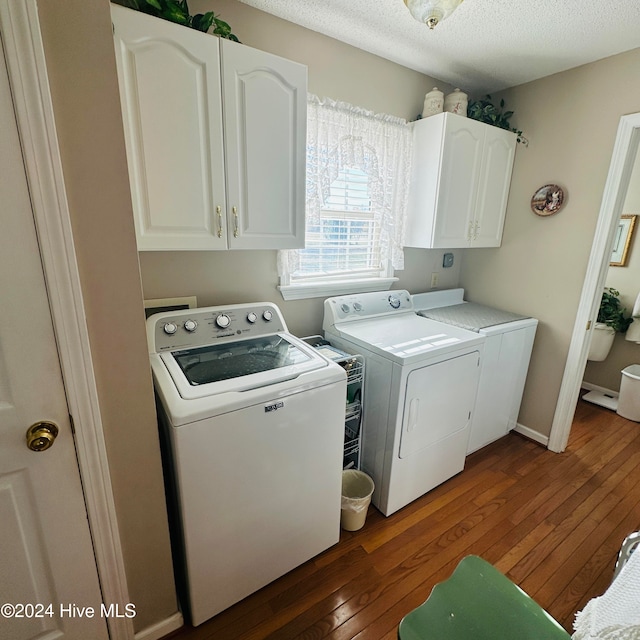 laundry area featuring independent washer and dryer, a textured ceiling, cabinets, and dark hardwood / wood-style floors