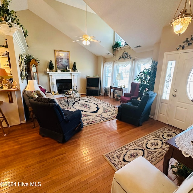 living room with hardwood / wood-style floors, high vaulted ceiling, and ceiling fan