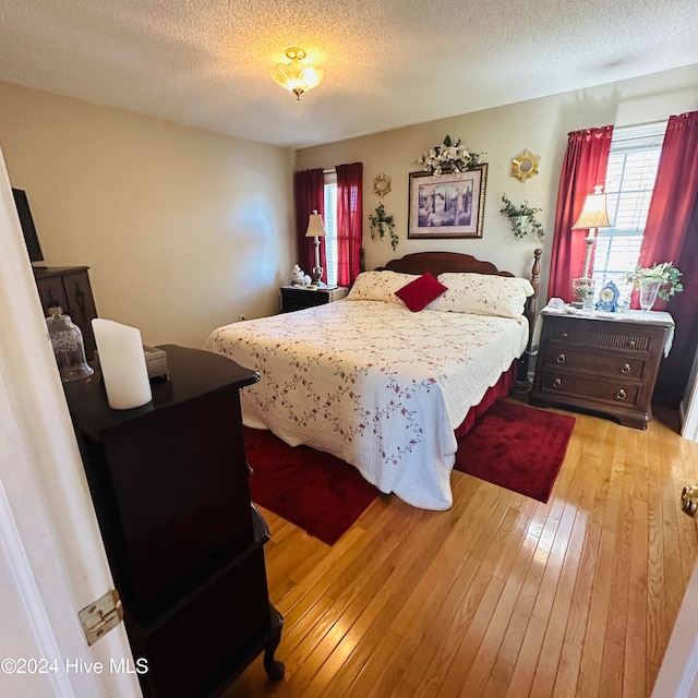 bedroom featuring light hardwood / wood-style flooring and a textured ceiling