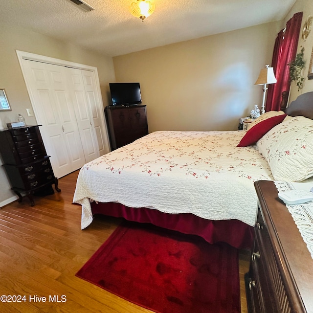 bedroom featuring a textured ceiling, hardwood / wood-style flooring, and a closet