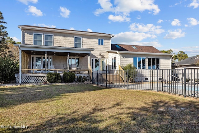 back of house featuring covered porch and a yard