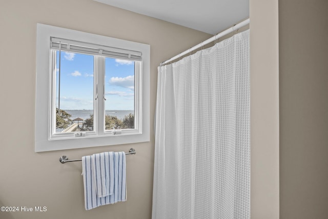 bathroom featuring a shower with shower curtain and a water view