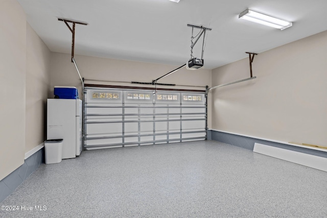 garage with freestanding refrigerator and a garage door opener