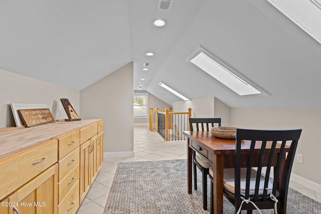 interior space featuring recessed lighting, visible vents, light tile patterned flooring, vaulted ceiling with skylight, and baseboards