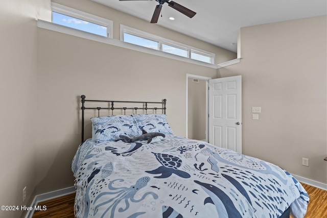 bedroom featuring a ceiling fan, baseboards, and wood finished floors