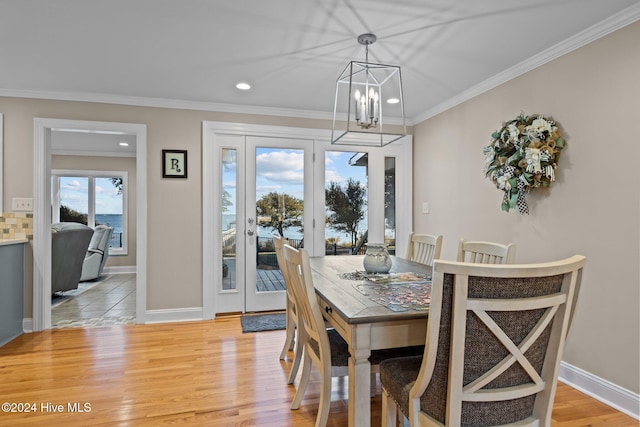 dining room featuring light wood-style flooring, recessed lighting, a notable chandelier, baseboards, and crown molding