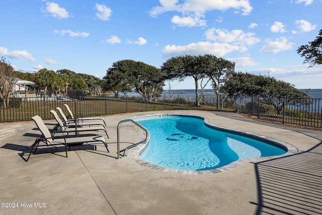 view of swimming pool with a patio and a water view