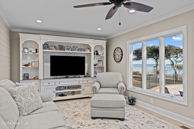 living room with ornamental molding, light wood-type flooring, and ceiling fan