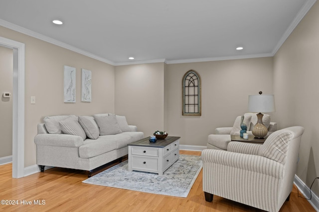 living area with ornamental molding, light wood-type flooring, and baseboards