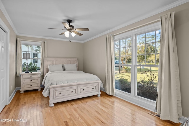 bedroom featuring crown molding, light hardwood / wood-style flooring, multiple windows, and ceiling fan